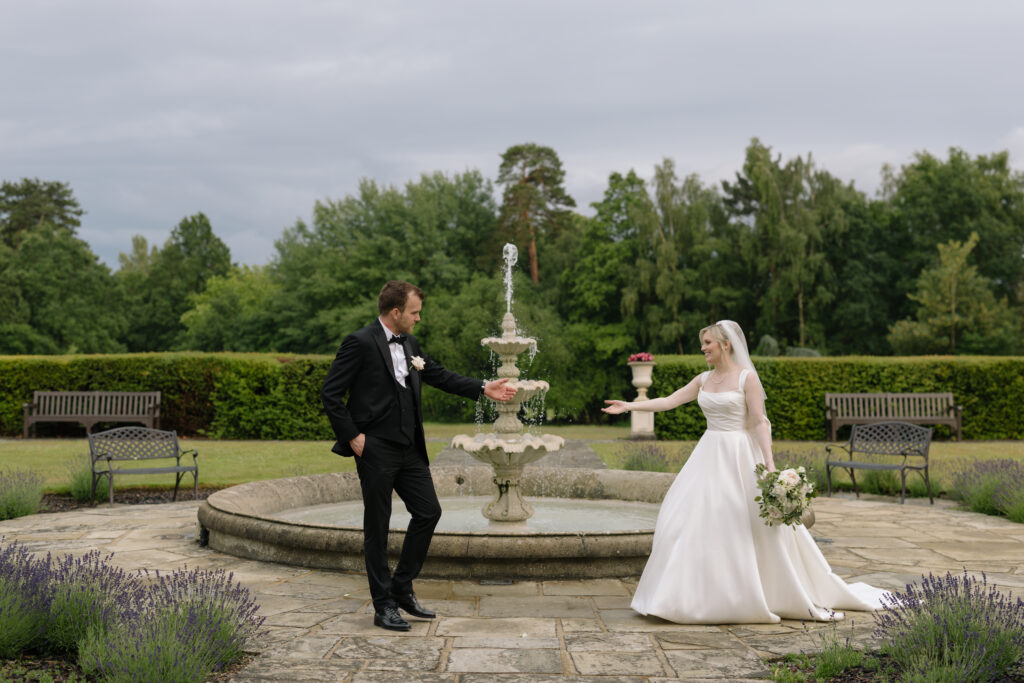 Bride and groom holding hands during wedding portrait session at East Hampstead Park in Surrey